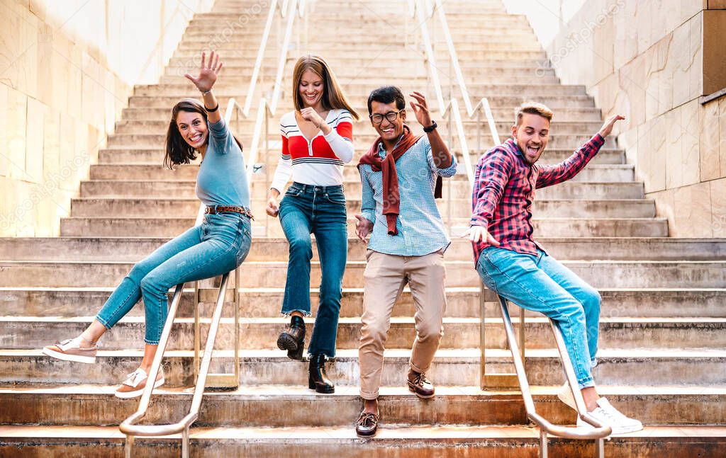 Multiethnic friends walking down stairs with stupid funny moves - Happy guys and girls having fun at urban city center on party mood - College students in travel holidays  - Bright warm filter