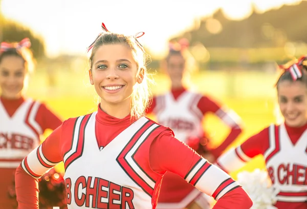 Retrato de uma jovem líder de torcida feliz em ação ao ar livre - Grupo de namoradas durante o treinamento esportivo de líder de torcida no ensino médio — Fotografia de Stock