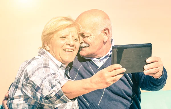 Senior feliz pareja tomando una selfie con tableta moderna - Concepto de ancianos sanos y la interacción con las nuevas tecnologías y tendencias —  Fotos de Stock