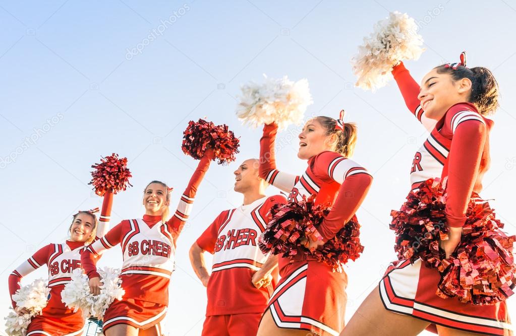 Group of cheerleaders in action with male coach - Concept of unity and team sport - Training at college high school with young female teenagers