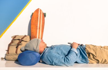 Dünya çapında backpacking smartphone - özgürlük ve alternatif yaşam tarzının Modern kavram - ucuz seyahat tutan bir feribot tekne geçiş sırasında bir dinlenme sahip genç hipster adam