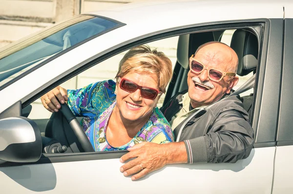 Happy senior couple ready for driving a car on a journey trip - Concept of joyful active elderly lifestyle with man and woman enjoying their best years — Stock Photo, Image