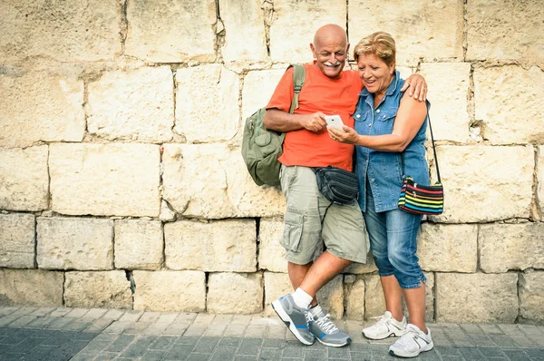Счастливая пожилая пара веселится с современным смартфоном - об активной старости и взаимодействии с новыми технологиями - Путешествие без возрастных ограничений — стоковое фото