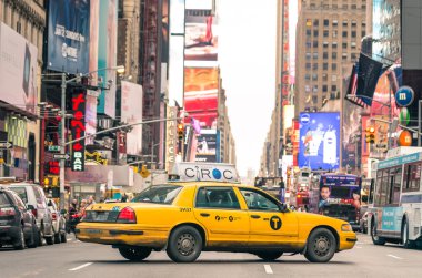 NEW YORK - DECEMBER 22, 2013: rush hour with yellow cab on 7th av. in Manhattan before sunset. Seventh Avenue is southbound below Central Park and a two-way street north of the park clipart