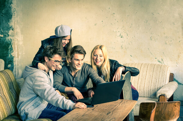 Группа молодых хипстеров лучших друзей с компьютером ноутбука в альтернативном месте города - Концепция дружбы и веселья с новыми тенденциями и технологиями - Беспроводное соединение и взаимодействие в Интернете
