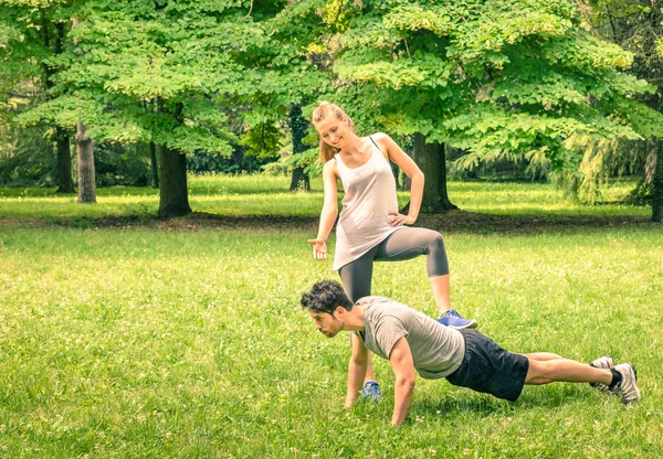 Girlfriend mengejek pacarnya saat pelatihan di taman - Pria dan wanita muda selama latihan musim semi dan kegiatan olahraga - Model kebugaran pasangan pria dan wanita yang bahagia setelah berlari — Stok Foto