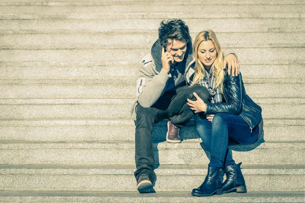 Beautiful hipster couple in love having a smartphone call - Modern concept of connection in a relationship together with mobile phone technology - City stairs urban lifestyle and everyday life rapport — Stock Photo, Image