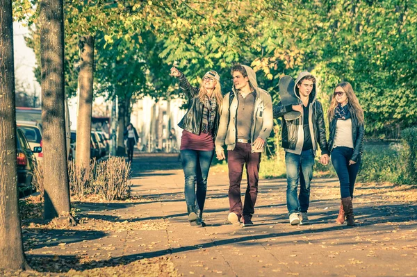 Group of happy best friends with alternative fashion look walking at the park - Hipster tourists having fun outdoors in sunny winter day - University students during a break hanging out together — Stock Photo, Image