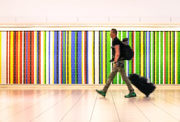 Człowiek, chodzenie w międzynarodowym porcie lotniczym z walizką i plecak - koncepcja życia alternatywnych podróżuje po całym świecie - hipster młody podróżnik w pośpiechu do samolotu na pokład po zameldowaniu — Zdjęcie stockowe