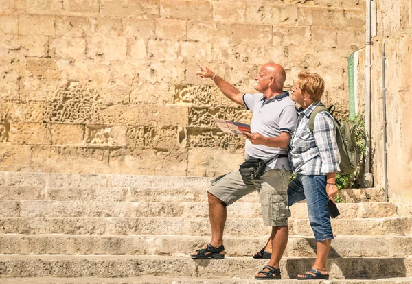 Glückliches Seniorenpaar erkundet die Altstadt von la Valletta mit Stadtplan - Konzept aktiver Senioren und Lebensstil ohne Altersbeschränkung - Reise zu den europäischen mediterranen Wundern — Stockfoto