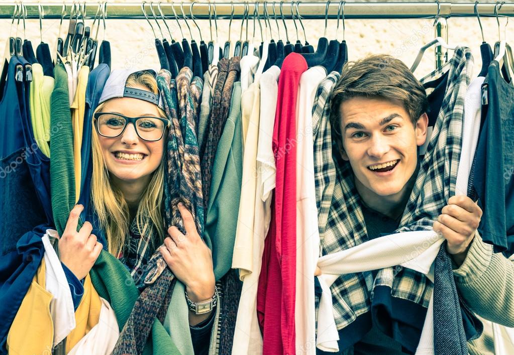 Young hipster couple in love at the weekly cloth market - Best friends sharing free time having fun and shopping in the old town - Lovers enjoying everyday life moments on a vintage filtered look