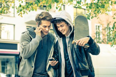 Having oyunculuk ile smartphone - arkadaşlarım yeni eğilimleri teknoloji ile serbest zaman paylaşımı - genç hipster kardeşler günlük yaşam anları manifatura zevk çocuklar modern akıllı telefon aygıt ile bağlı.