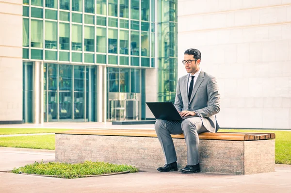 Unga hipster business man sitter med laptop i business center - moderna begreppet teknik wifi-anslutning - stilig affärsman arbeta utomhus med dator ansluten med wirless internet — Stockfoto