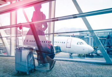 Kavram kadın ve bavul vintage süzülmüş düzenleme ile hızlı Havaalanı terminal kapısı - Double exposure bak uçak içinde belgili tanımlık geçmiş odaklı - Menekşe marsala güneş patlaması için taşıma ile seyahat