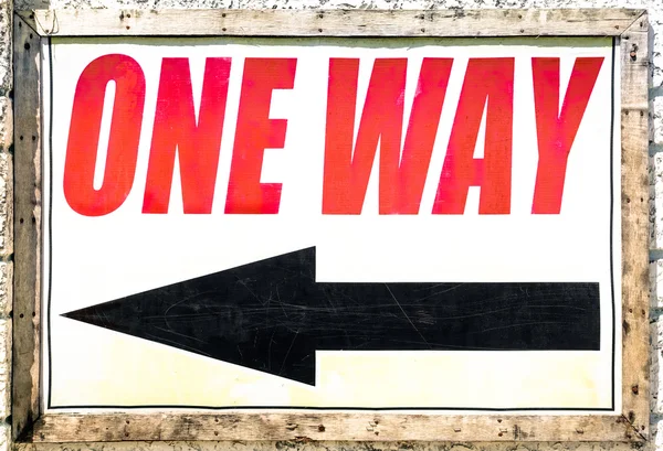 Vintage one way sign with black arrow showing the direction under red letters — Stock Photo, Image