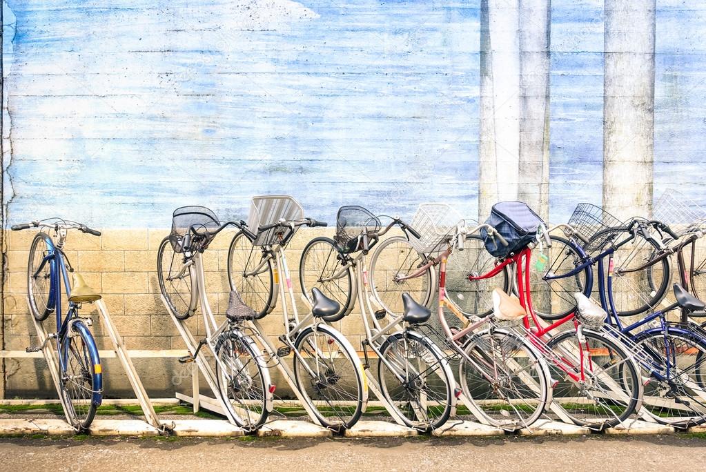 Multicolored vintage bicycles in metal rack in Tokyo city - Urban ecological transportation concept with retro bikes - Ryogoku residential district in the japanese world famous capital - Logos removed