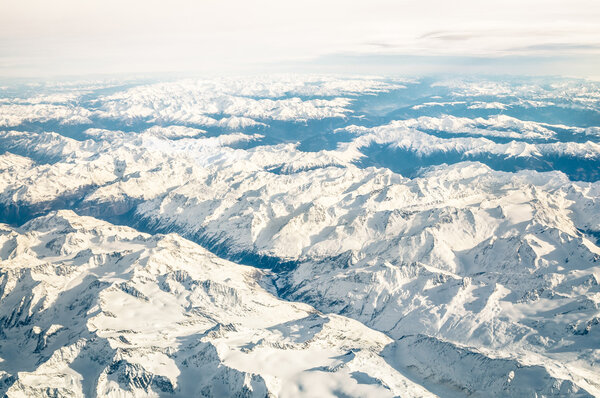 Aerial view of italian Alps with snow and misty horizon - Travel concept and winter vacation  on white snowy mountains - Trip wander to exclusive luxury destinations