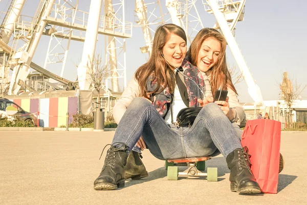 Beste vrienden genieten van tijd samen met smartphone afspeellijst in een zonnige lentedag - nieuwe trends en technologie concept met hipster vriendinnen plezier buitenshuis - warme vintage gefilterd blik — Stockfoto