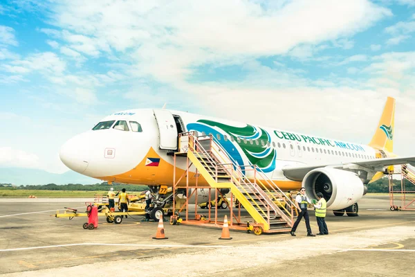 PUERTO PRINCESA, FILIPINAS - 15 DE FEBRERO DE 2015: personal que se desplaza por los aviones de Cebú Pacífico después de aterrizar en el Aeropuerto Internacional de Puerto Princesa. El centro principal está en el aeropuerto Ninoy Aquino en Manila —  Fotos de Stock