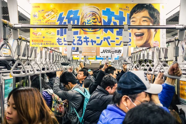 Tokio - 26 lutego 2015: pełny pociąg w godzinach szczytu w podziemiach. Sieć metra połączone Tokio i Toei Metro liczy 290 stacje i linie 13. Ciasno wykadrowany skład. — Zdjęcie stockowe