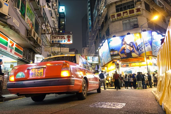 HONG KONG, FEBRUARY 25, 2015: taksi merah di persimpangan jalan dengan Jalan Carnavon dan Prat Ave dekat Jalan Nathan di Tsim Sha Tsui, daerah perkotaan di selatan Kowloon, bagian dari Kabupaten Yau Tsim Mong — Stok Foto