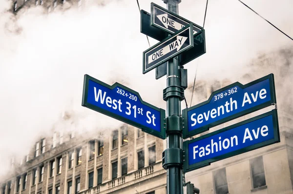 Modern street sign and vapor steam in New York City - Urban concept and road traffic directions in Manhattan downtown - American world famous capital destination on dramatic desaturated filtered look — Stock Photo, Image