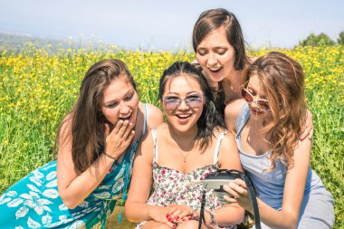 anlık görüntü anlık dijital fotoğraf makinesi - mutlu dostluk fotoğrafları izlerken kırsal piknikte çok ırklı kız kavramı gençler ve yeni teknoloji eğilim - güneşli öğleden sonra renk tonu ile eğlenceli