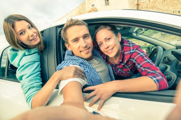 Handsome guy having fun with girlfriends - Best friends taking selfie at car trip on the road - Happy friendship and wanderlust concept with people traveling together - Soft vintage filtered look — Stock Photo, Image