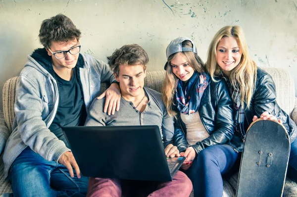 Group of young hipster best friends with computer in urban alternative studio - Concept of friendship and fun with new trends and technology - Vintage filtered look with soft focus on guy with laptop — Stock Photo, Image