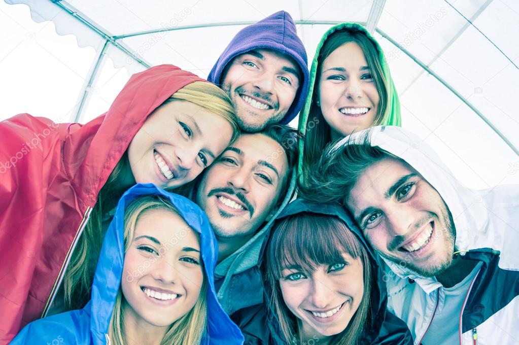 Best friends taking selfie wearing hoodies outdoors - Happy friendship concept with young people looking at camera having fun together - Cold cyan filtered look with focus in the middle of the frame