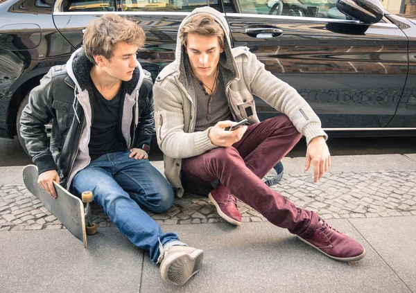 Jovens irmãos de moda hipster se divertindo com smartphone Melhores amigos compartilhando tempo livre com telefone inteligente Momentos da vida cotidiana conectados com dispositivos modernos Foco suave no rosto dos caras — Fotografia de Stock