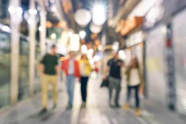 Sfocato sfondo astratto sfocato di persone che camminano per strada di notte con - concetto di vita notturna con giovani amici appendere insieme nel centro della città - freddo sguardo filtrato neutro — Foto Stock