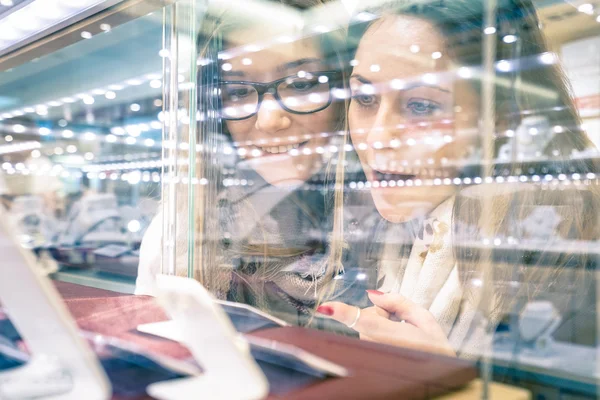 Young beautiful girlfriends at jewellery store - Best friends sharing free time having fun at shopping mall - People enjoying everyday life moments - Shallow depth of field with focus on woman at left — Stock Photo, Image