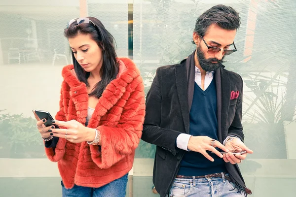 Hipster çift üzgün anı cep telefonunu kullanarak birbirimizi görmezden - apati üzüntü için yeni teknolojiler bağımlısı kavramı - erkek ve kız arkadaşı break up akıllı telefonlar bağımlılığı ile — Stok fotoğraf