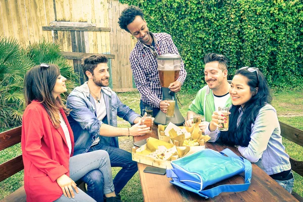 Grupo multirracial de amigos felizes comendo e brindando na festa de churrasco jardim - Conceito de felicidade com os jovens ao ar livre desfrutando de comida de piquenique juntos - Vintage olhar filtrado — Fotografia de Stock