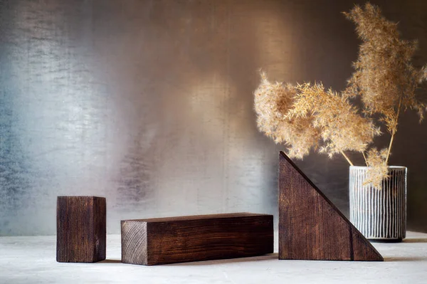 Pódiums de madera y un arreglo casual de hierba japonesa de pampas en un vaso.Pódiums de madera y un arreglo casual de hierba japonesa de pampas en un jarrón. Fotos de stock