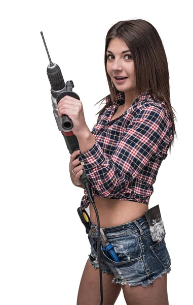 Молодая сексуальная девушка в джинсовых шортах, держит электрическую дрель. Белый изолированный фон . — стоковое фото