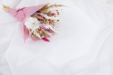 Beyaz tekstil üzerinde kurutulmuş güzel çiçekler.