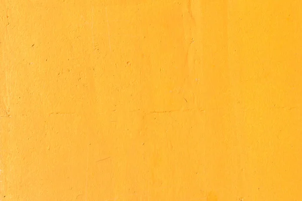 The wall of the house painted with yellow paint