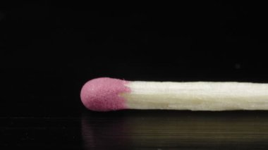 Siyah bir arkaplanla yakın çekim eşleşmesi. Ekstrem makro. Ayrıntılı olarak odun ve sülfür.