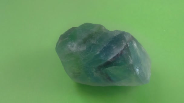 Fluorita mineral sobre fondo verde. Piedra decorativa y ornamental. Fluorspar vista de cerca. — Vídeos de Stock