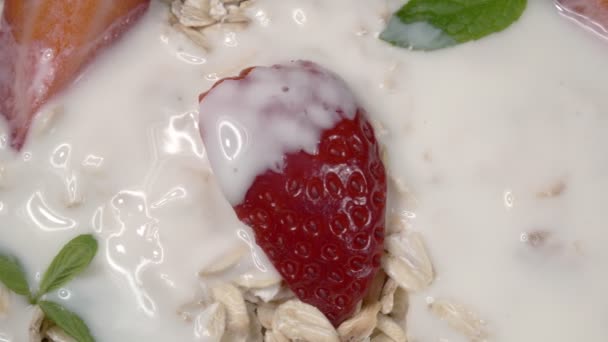 Fiocchi d'avena con fragole e menta nel latte. Una colazione veloce Primo piano. — Video Stock