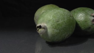 Feijoa yakın plan. Siyah arka plan. Organik meyve.