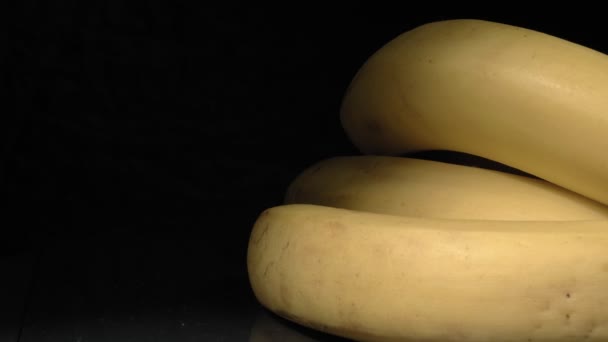 Gros plan sur les bananes. Fruits sur fond noir. — Video