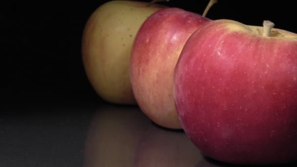 Äpplen på nära håll. mogen frukt på en svart bakgrund. — Stockvideo