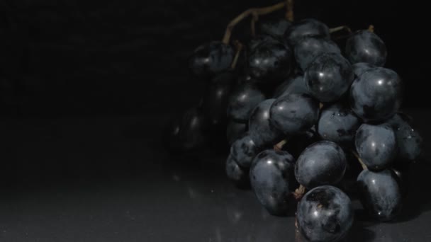 Uvas orgânicas close-up. Fundo preto. Uvas escuras para sobremesa. — Vídeo de Stock