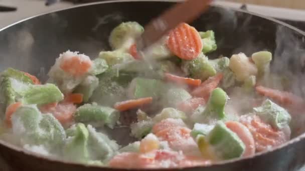 Les légumes surgelés sont cuits dans une poêle à frire, mettant en évidence la vapeur. — Video