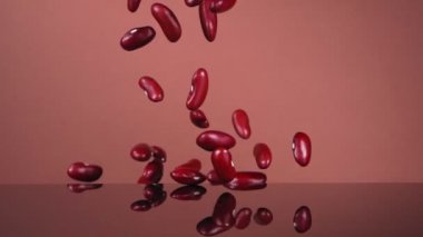 Kahverengi arka planda uçan kırmızı fasulyeler. Kırmızı fasulye. Süper yavaş çekim.