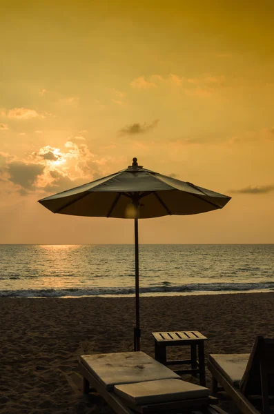 Siluetas de sombrillas de playa puesta de sol y cielo — Foto de Stock