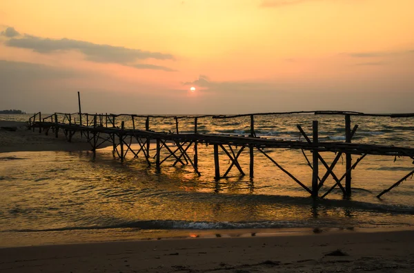 Puente de madera en el mar y puesta de sol — Foto de Stock